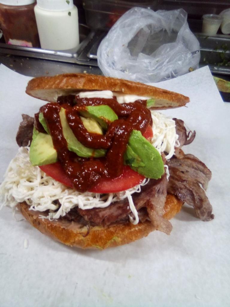 Carne Azada Cemita · Grilled beef. Homemade sesame seed roll, layered with refried beans, pulled out oaxaca cheese, avocado, chipotle, raw onions, papalo and mayo.
