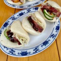 Char Siu Buns (3) · Slices of char siu (roast pork) on folded steamed buns (3), with pickles, cabbage, and house...