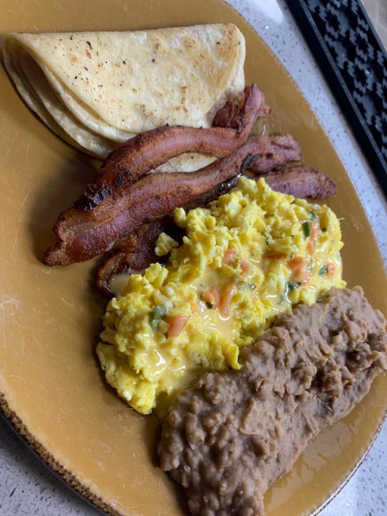 Eggs Mexican Plate · Scrambled eggs topped with chile con queso and pico de gallo. Choose your protein. Served with refried beans and 3 corn tortillas.