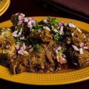Goat Pepper Fry · Tender goat cooked with peppercorn, coconut flakes, and curry leaves.