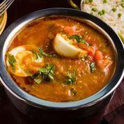 Anda Curry · Boiled egg in yogurt, onion, and tomato sauce topped with chopped cilantro, onions, and toma...