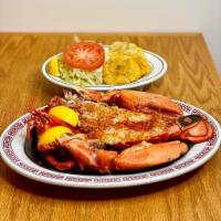 Langosta Asado · Broiled lobster served with salad and tostones.