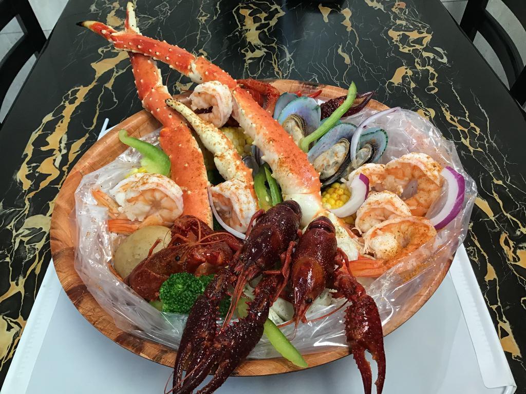 seafood boil bag combo #65 · 1 LB king crab legs +1/2 LB crawfish +1/2 jumbo shrimp(peeled cleaned)+1/2 green mussels seasoned with butter garlic served with potato corn broccoli pepper and onions.please choose seasoning and spicy level