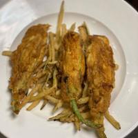 Stuffed Zucchini Blossoms · Garden fresh zucchini flowers stuffed with goat cheese, battered and fried, over a bed of ju...