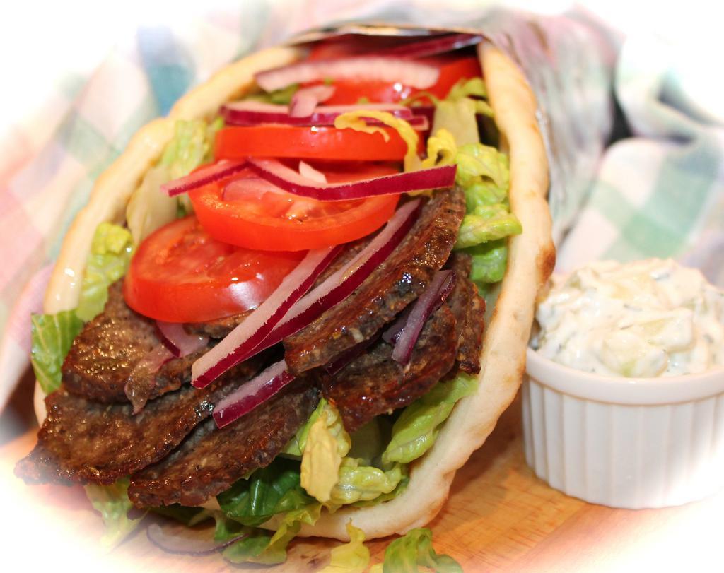 Lamb Gyro · Slow-cooked Lamb on a pita served with lettuce, tomato onions, cucumbers, and white sauce