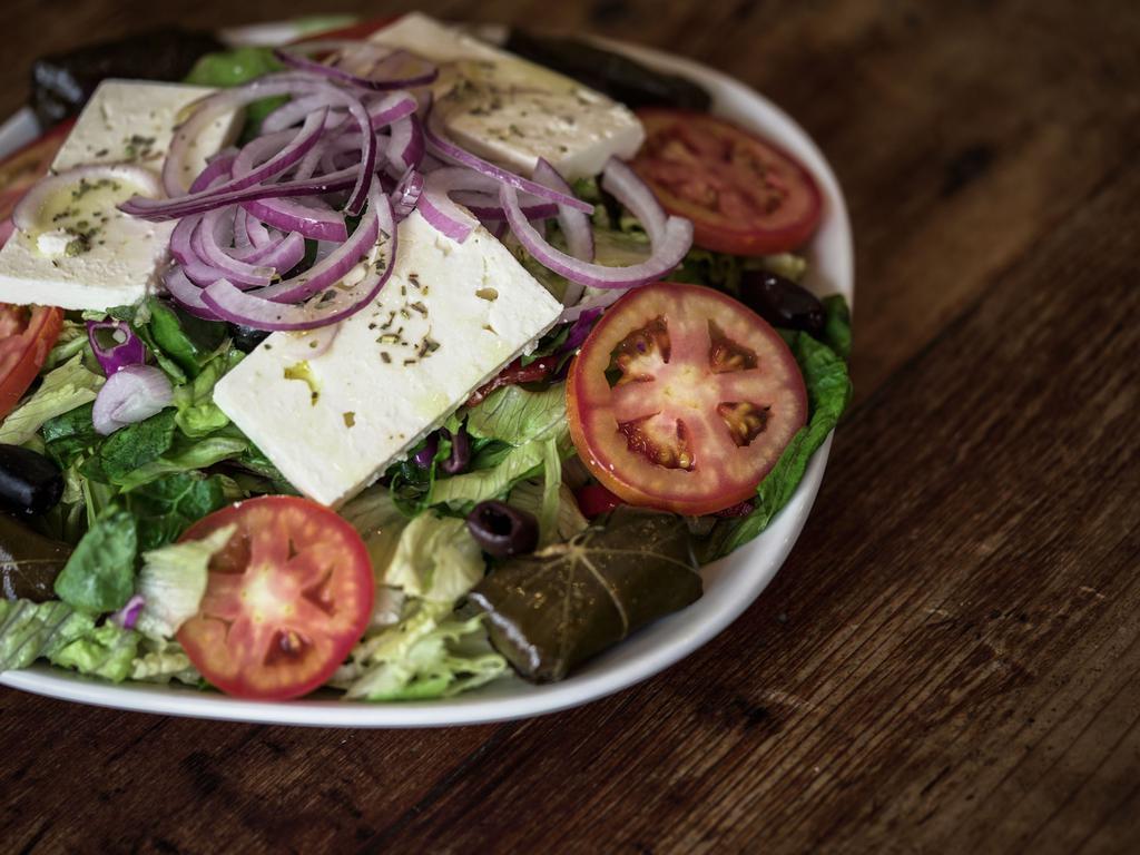 Greek Salad · Mixed greens, tomatoes, cucumbers, red peppers, grape leaves, feta cheese, olives and red onions.