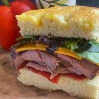 Roast Beef and Cheddar Sandwich · Tender roast beef, aged cheddar, roasted peppers, lettuce and garlic-herb oil.