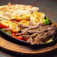 Fajitas Mixtas · Beef, chicken and shrimp fajitas, served with Mexican rice, refried beans, guacamole, pico d...