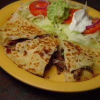 Quesadilla Rellena · Large grilled flour tortilla stuffed with cheese and beans seasoned chicken, pastor adobado ...