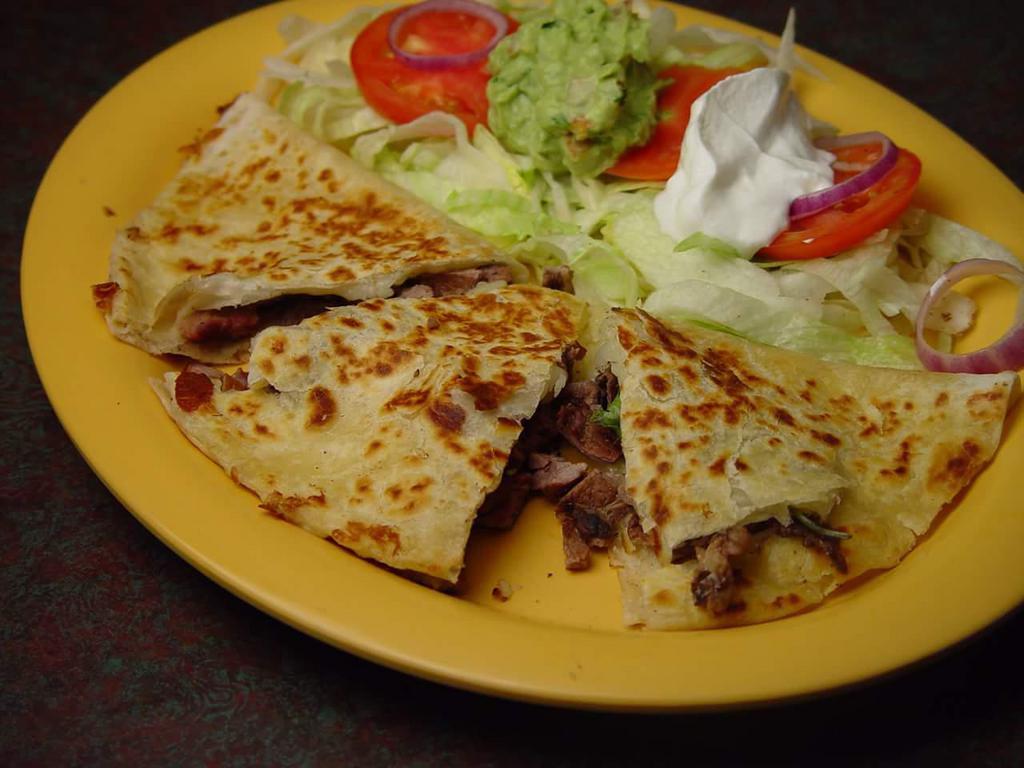 Fajita Quesadilla · Large flour tortilla stuffed, with your choice of chicken or beef fajitas, then grilled and garnished with lettuce, guacamole, sour cream and pico de gallo. Served with rice and beans.
