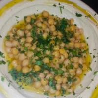 Hummus Masabacha · Topped with the whole chickpeas. Served with 2 pitas and a side of pickles.