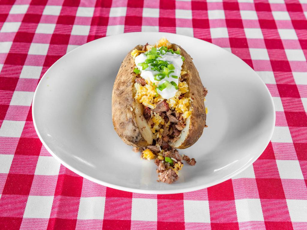 Loaded Brisket Baked Potato · Baked potato topped with chopped brisket. Toppings include butter, beans, shredded cheese, sour cream, and chives.