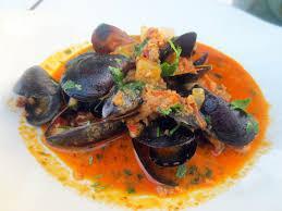 Mussels y Chorizo · Steamed mussels with tomato and chorizo broth.