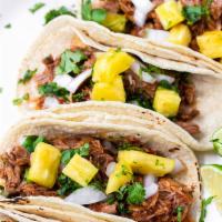 Al Pastor Taco (1pc) · mexican style braised pulled pork, pineapple, avocado, tomatillo salsa, pico de gallo on a c...