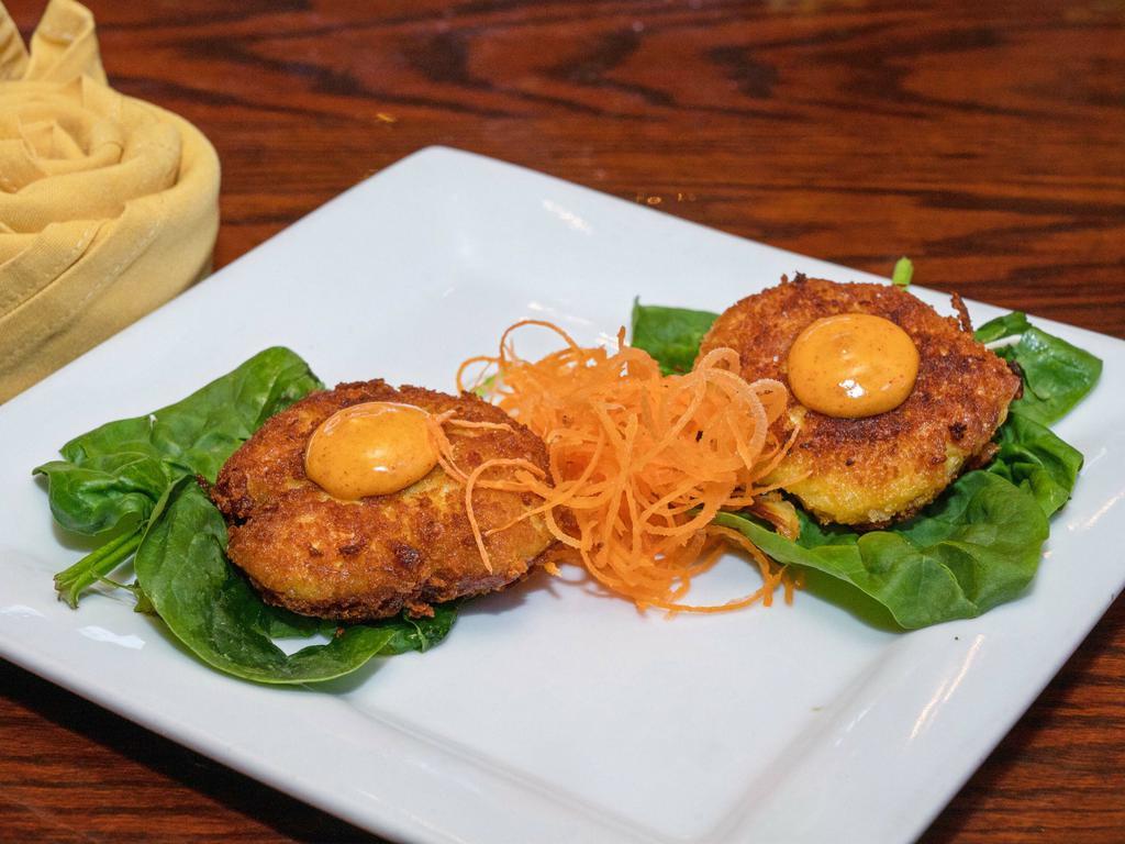 Crab Cake · Two pan seared lump meat cake over greens.