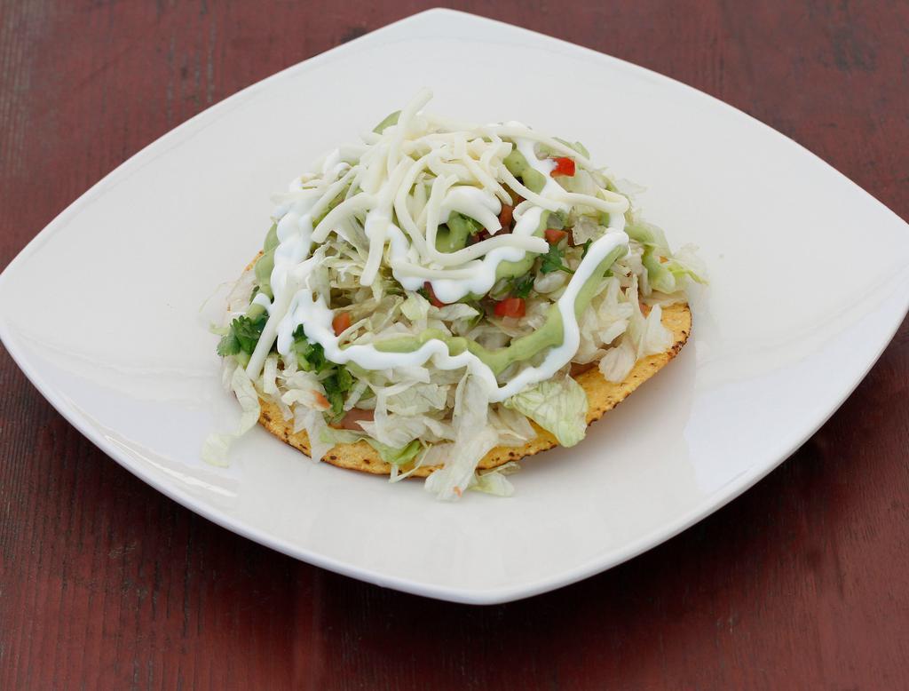 Veggie Tostadas · Crispy flat corn tortilla with beans, lettuce, tomatoes, cheese, guacamole and sour cream.