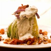 BLT Wedge Salad · Iceberg lettuce, smoked bacon, sundried tomatoes, grilled red onion, and crumbled bleu chees...