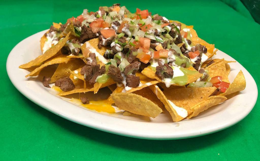 Super Nachos · A bed of tortillas chips topped with refried beans, mozzarella cheese, meat of your choice garnished with pico de gallo, sour cream and guacamole 
