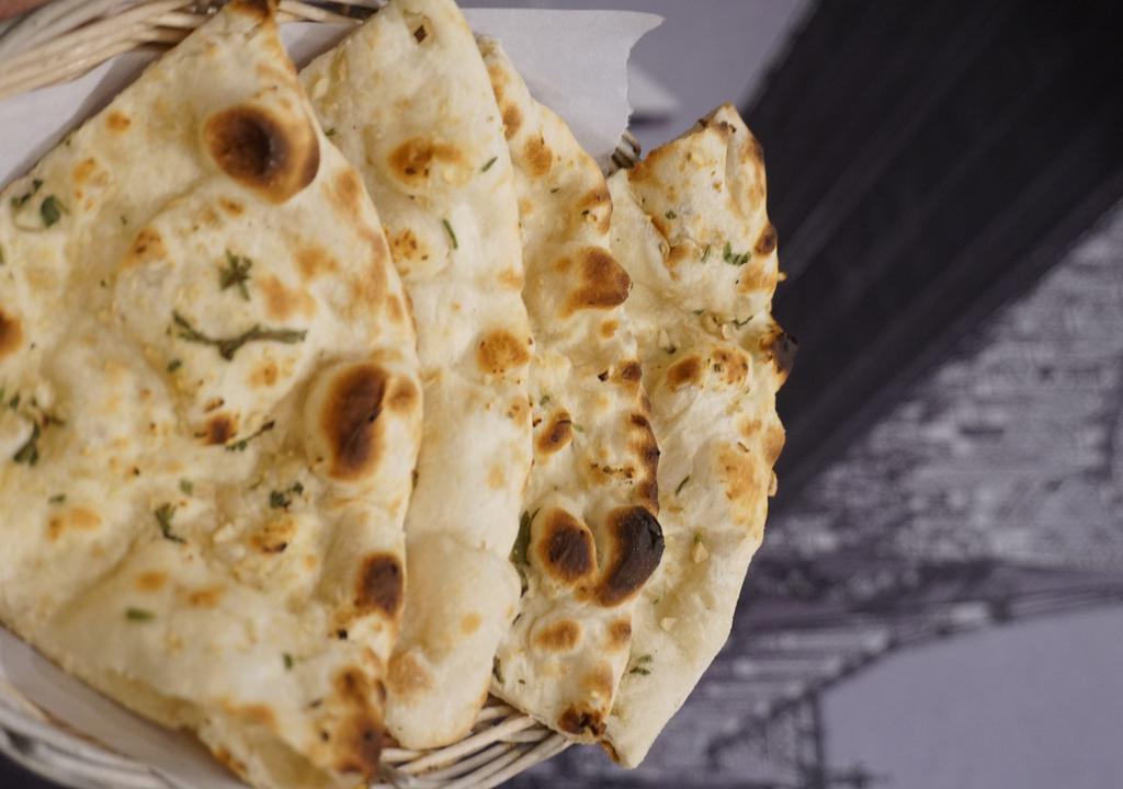 Garlic Naan · Naan garnished with freshly chopped garlic, cilantro, olive oil and baked in tandoor.