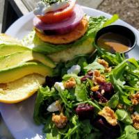 Salmon burger with side salad  · Salmon burger with red onion tomato and avocado on brioche.
With side salad arugula,spicy wa...