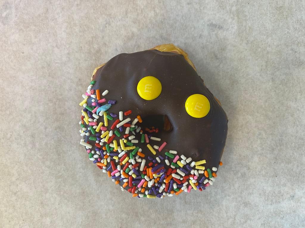 Yum-Yum M&M Donut · Raised donut dipped in milk chocolate and topped with M&M's and sprinkles