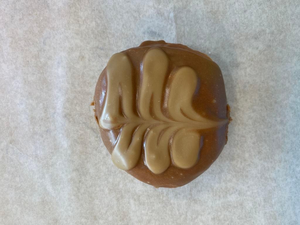 Portland Cream · Raised donut dipped in caramel, drizzled with maple, and filled with Bavarian cream