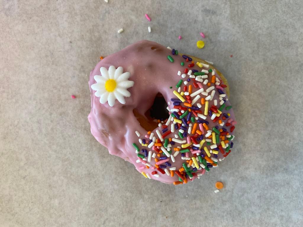 Strawberry Frosted Donut · Raised donut dipped in strawberry frosting and coated with sprinkles