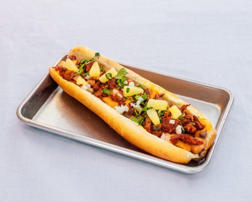 Pastor Dog · Bacon wrapped frank, beans, melted cheese, pastor meat, grilled onions, cilantro, pineapple, Frida's sauce.