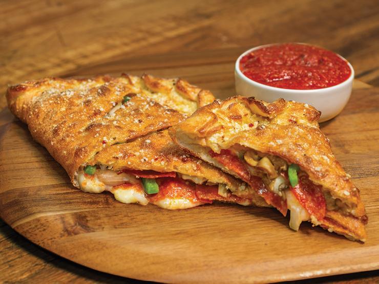 Deluxe Calzone · Our handmade dough stuffed with pepperoni, Italian sausage, mushrooms, green peppers, onions and our signature three cheeses; served with a side of our original pizza sauce