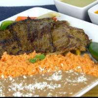 Carne Asada · Beef steak served with bell peppers, onions rice and refried beans.