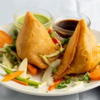 Vegetable Samosa  · Crisp Pastries stuffed with potatoes, green peas and spices