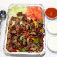 Halal Lamb over Rice Platter · Halal lamb over bed of yellow rice Served with a side of lettuce and tomatoes .