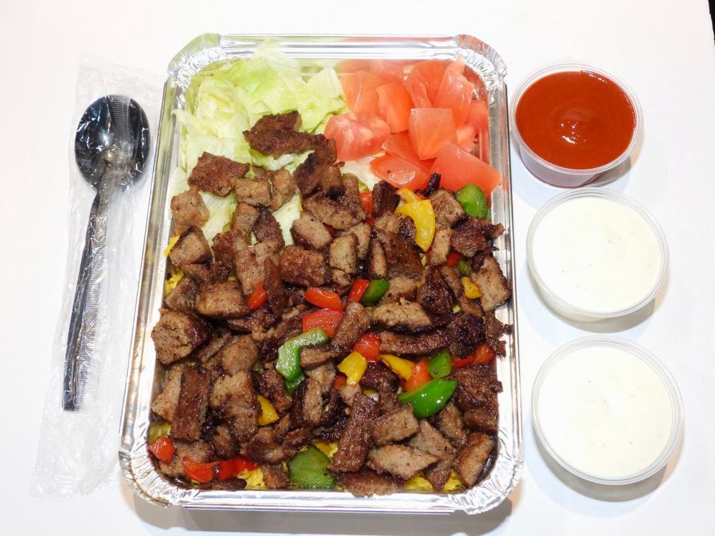Halal Lamb over Rice Platter · Halal lamb over bed of yellow rice Served with a side of lettuce and tomatoes .