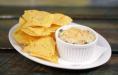Spinach and Artichoke Dip · A traditional creamy dip, topped with Parmesan cheese and served with tortilla chips. 