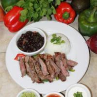 Carne Azada · Mexican style steak. Marinated flank steak, served with black bean soup, white rice and garn...