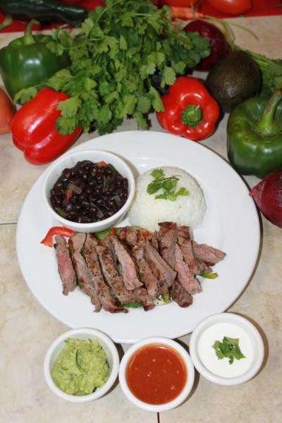 Carne Azada · Mexican style steak. Marinated flank steak, served with black bean soup, white rice and garnished with pico and guacamole.
