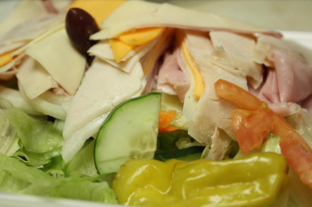 Chef Salad · Romaine lettuce, Roma tomatoes, red onions, cucumbers, green peppers, ham and turkey rolled and cut with provolone and American cheese slices, Greek kalamata black olives and imported pepperoncini.