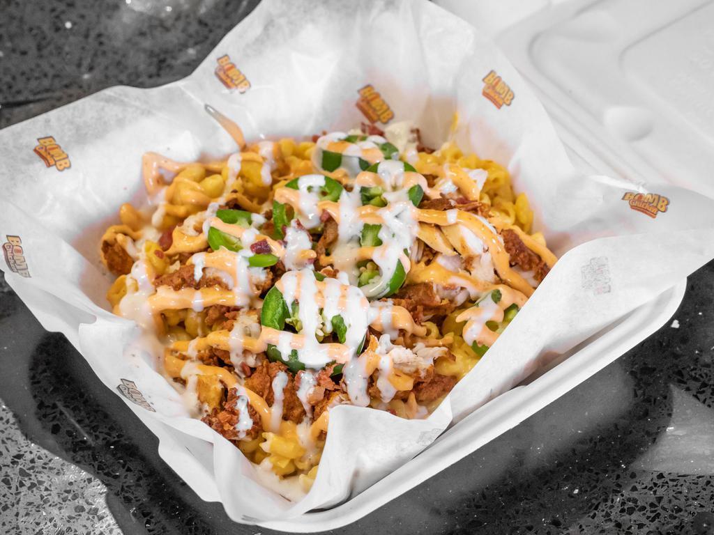 Spicy Bomb Bowl · Half a pound of handcrafted chicken tenders served on top of your choice of mac and cheese or cheese fries, bacon, street corn and a bomb sauce drizzle.