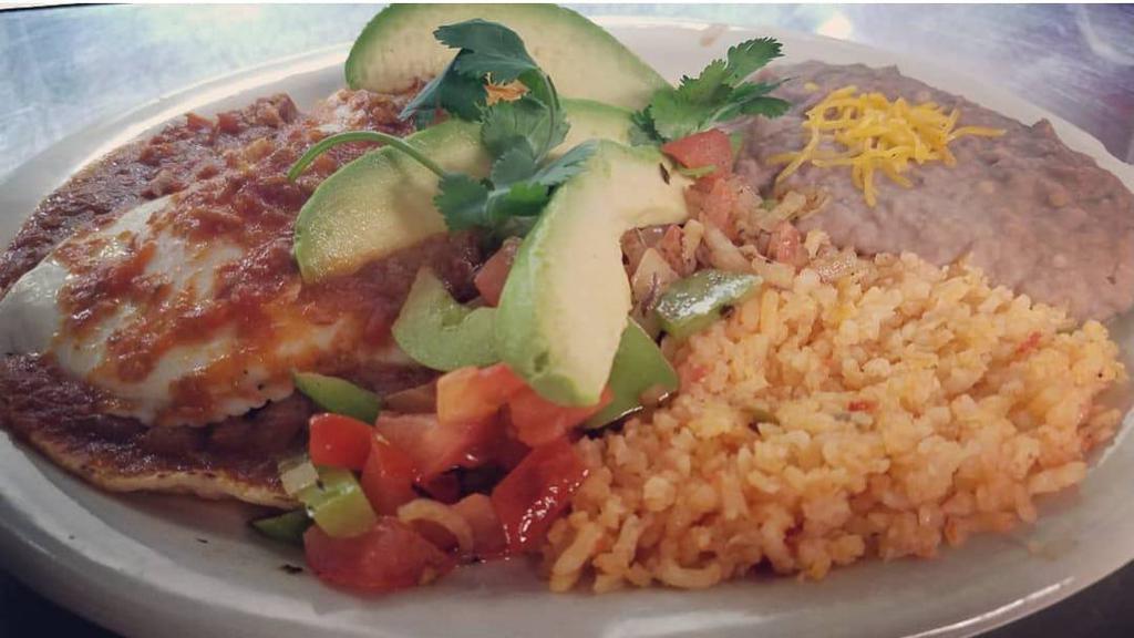 Huevos Rancheros · 2 corn tortillas topped with beans, 2 eggs, and our chile verde pork, served with grilled onions, bell peppers, avocado sliced, sour cream, rice, and beans.