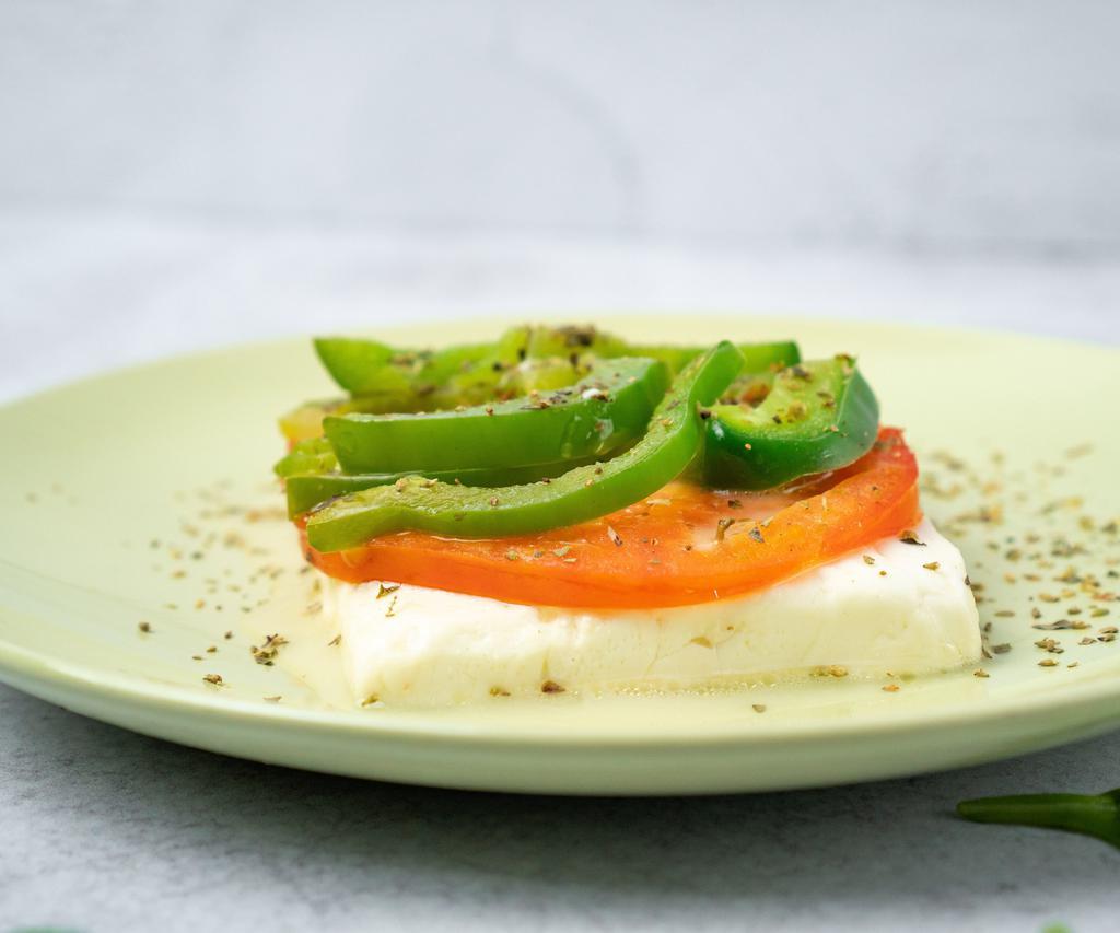 Feta Fournou (Baked Feta Cheese) · Feta cheese baked with a slice of tomato and a slice of green pepper, topped with extra virgin olive oil and oregano.