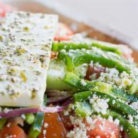 Horiatiki (Village Salad) · Tomatoes, cucumbers, red onions, green peppers, feta cheese, olives, and extra virgin olive ...