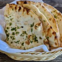 Garlic Chili Naan · Leavened bread touched with fresh shredded garlic and chilli paste then baked in our clay ov...