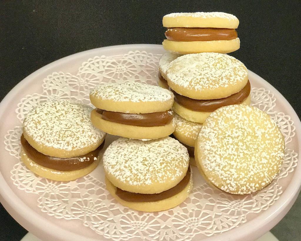 Large Dulce de Leche Alfajor Cookie · Scrumptious South American style shortbread cookie sandwiches that are filled with our signature dulce de leche (caramel) and drenched in confectioners’ sugar. These cookies will keep you coming back!