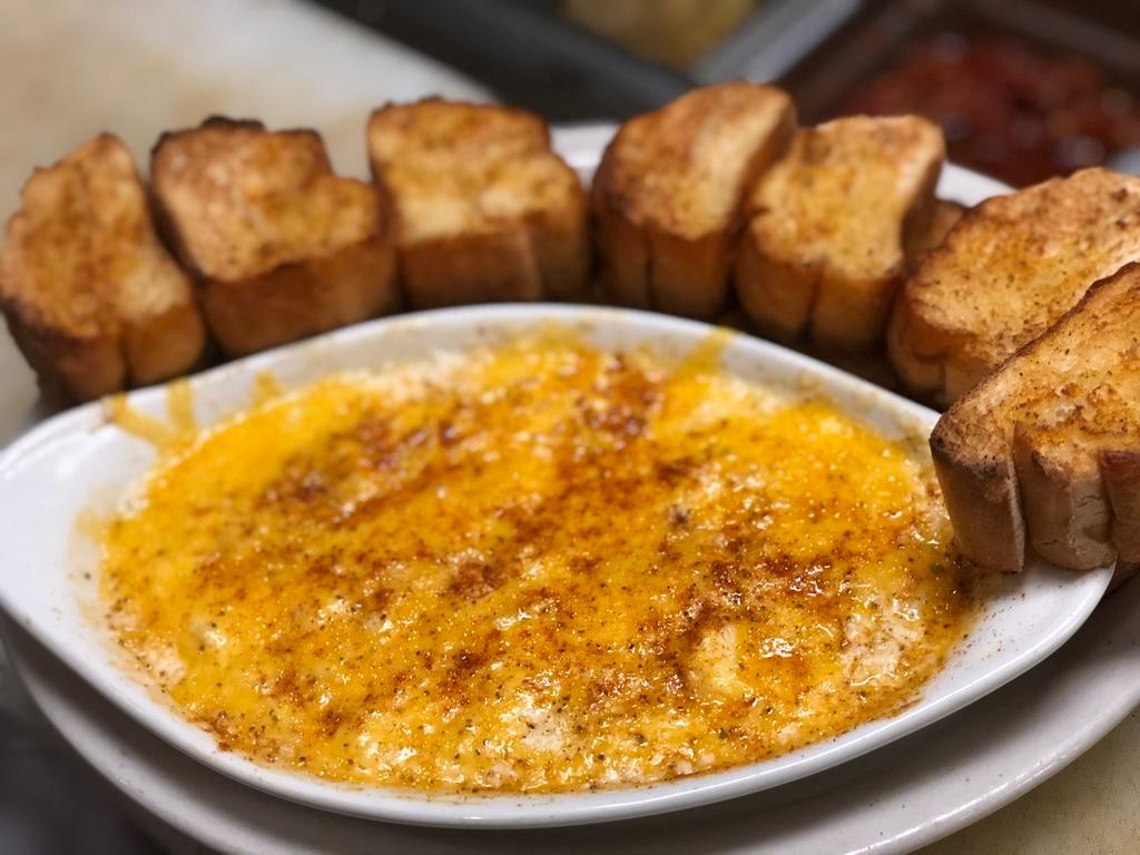Crab Dip · Crab dip topped with cheddar cheese and Old Bay served with Old Bay Toast.