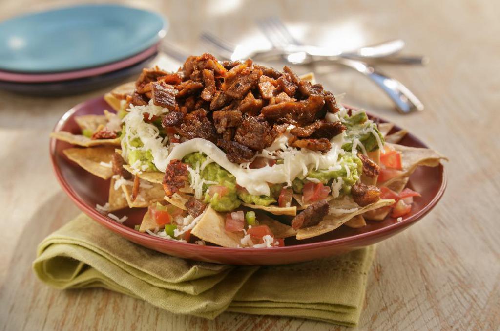Nachos · Chips topped with choice of meat, beans, pico de gallo, sour cream, cheese, and guacamole.