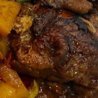 Brown Stew Chicken · Brown stew served with rice and peas and side.