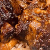 Oxtail · Served with rice and peas or jollof rice, and sides.