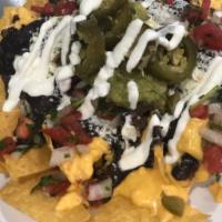 Ground Beef Nachos  · Fried tortilla chips with refried beans, tomato, jalapeños, topped with shredded cheese, and...