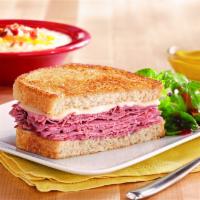 Corned Beef Reuben · Lean corned beef, grilled sauerkraut and melted Swiss cheese on grilled rye bread with a sid...