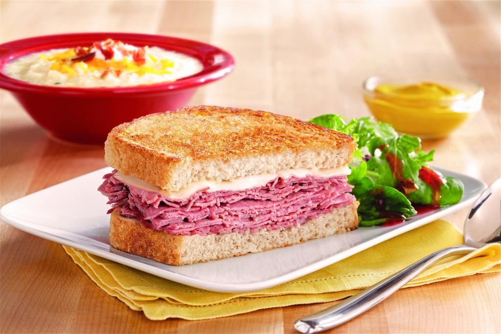 Corned Beef Reuben Sandwich · Corned beef, sauerkraut and melted Swiss cheese on grilled rye bread served with Thousand Island dressing.